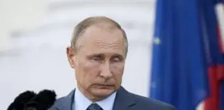 Władimir Putin, prezydent Rosji, na tle rosyjskiej symboliki państwowej