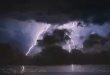 Pioruny uderzające za ciemnymi chmurami burzowymi nad panoramą miasta