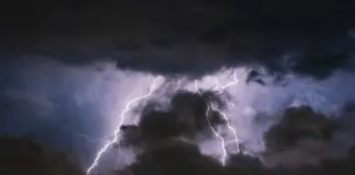 Pioruny uderzające za ciemnymi chmurami burzowymi nad panoramą miasta