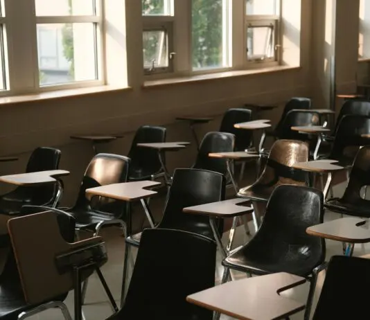 Pierwszy dzwonek już jutro. Ferie, egzaminy i 15 dni wolnego na przełomie roku Pusta sala lekcyjna z rzędami ławek i światłem wpadającym przez okna
