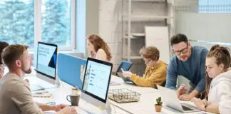 Koniec skakania po etatach. Dwudziestolatkowie odkryli, że bardziej opłaca się zostać w jednej firmie Młodzi pracownicy pracujący przy komputerach w nowoczesnym biurze