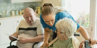 Opiekunka spędzająca czas ze starszymi osobami przy stole