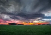Burzowe chmury nad polem podczas zachodu słońca