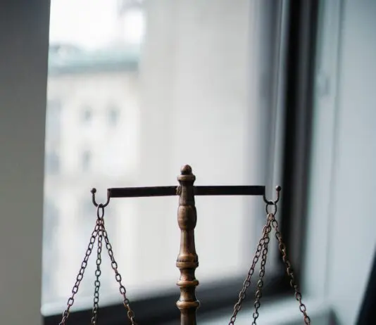 Waga sprawiedliwości i młotek sędziowski na biurku