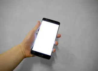 Dłoń trzymająca smartfon z pustym ekranem