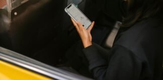 240 tysięcy kierowców Ubera mówi „dość”. Gigantyczny pozew także z udziałem Polaków Osoba w samochodzie trzymająca smartfon z aplikacją przewozową