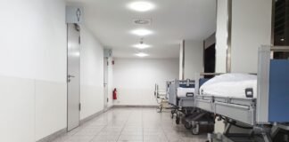 Szpitalne łóżka stojące na korytarzu oddziału