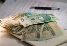 Plik polskich banknotów leżący na dokumentach
