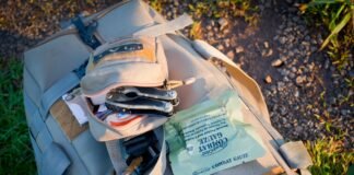 Godzina na spakowanie, spokój na lata. Jak przygotować plecak ratunkowy bez paniki i zbędnych gadżetów Plecak ewakuacyjny w kolorze khaki z rozłożonym obok ekwipunkiem awaryjnym