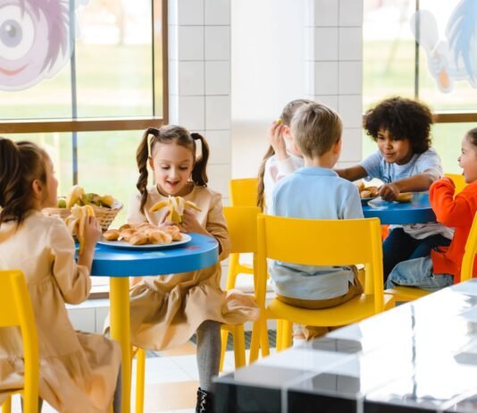 Dieta planetarna nie w smak uczniom? Rodzice z Otwocka powiedzieli, co dzieci myślą o nowych obiadach Dzieci jedzące wspólnie posiłek na szkolnej stołówce
