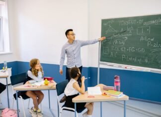 Nauczyciel wskazuje na tablicę podczas lekcji w klasie
