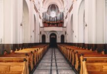 Puste drewniane ławki we wnętrzu kościoła katolickiego